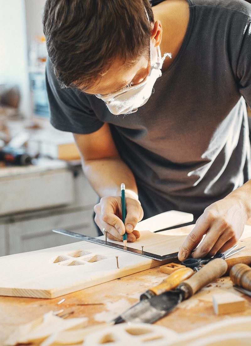 The carpenter works with a tree A man carves a tree. The carpenter works in a studio. An engineer provides a tree shape